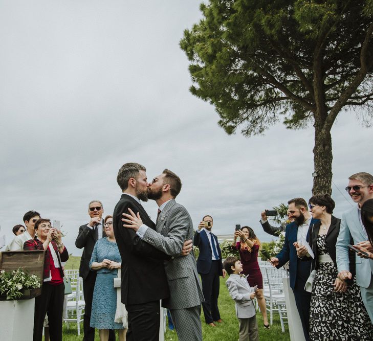 Grooms kiss after wedding ceremony