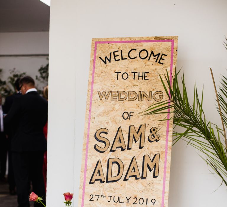 Wooden wedding sign with floral decoration at industrial wedding ceremony