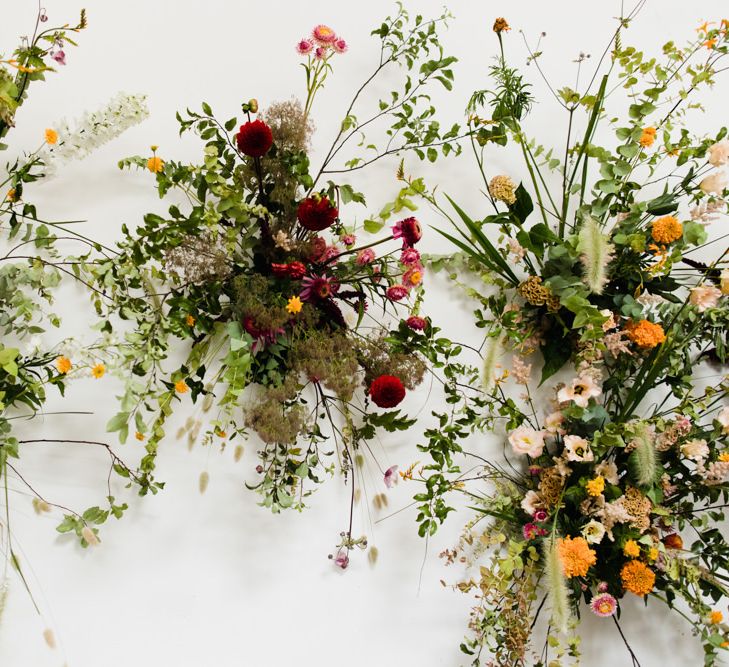 Orange and Pink floral decor with lots of foliage at industrial wedding ceremony