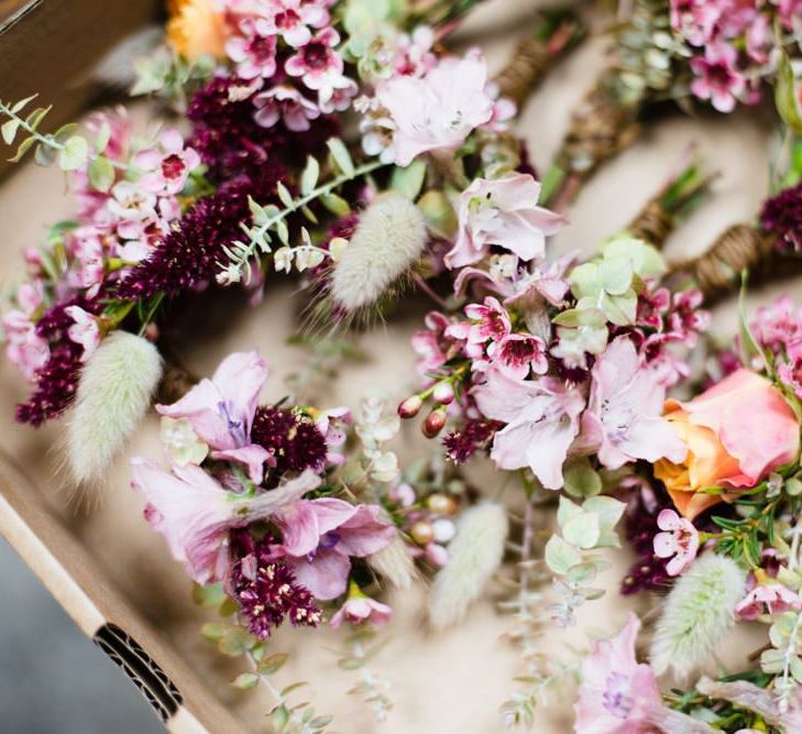 Purple, pink and orange floral decor at industrial wedding with casual styling