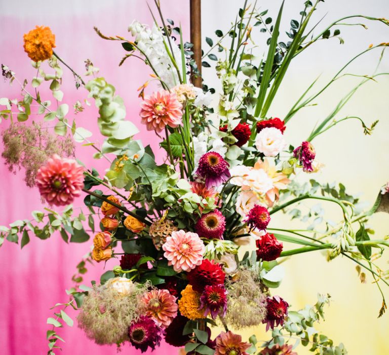 Purple, pink and orange floral decor at industrial wedding with casual styling