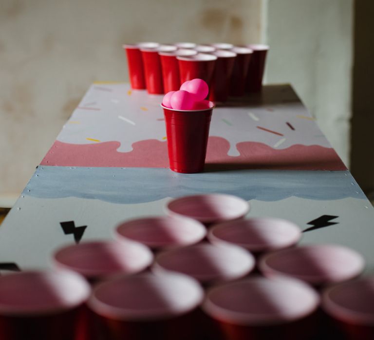 Beer pong game at casual wedding reception with industrial