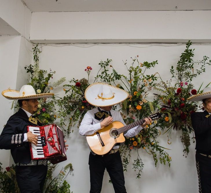 Mariachi band at industrial wedding reception with bright floral decor