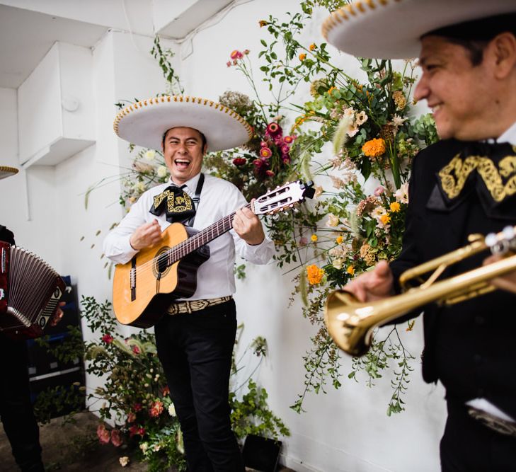 Mariachi band at wedding reception in London with bright floral decor and industrial styling