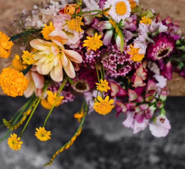 Purple and orange floral arrangements at industrial wedding in London