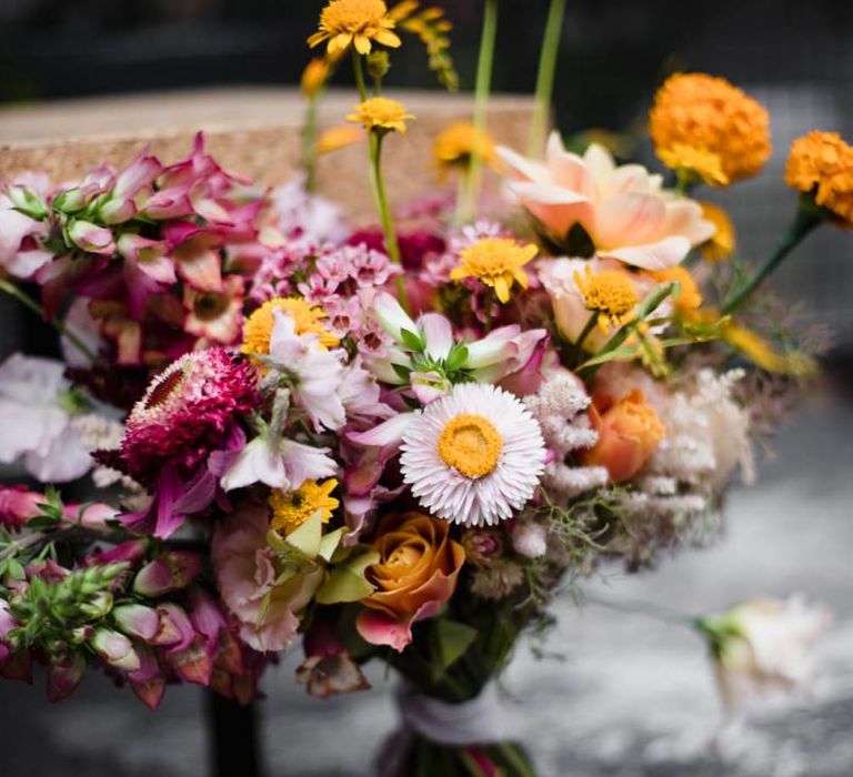 Purple and orange floral arrangements at industrial wedding in London