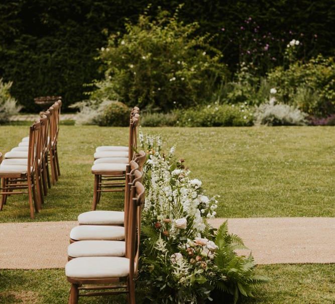 aisle chairs and wedding flowers at outdoor ceremony