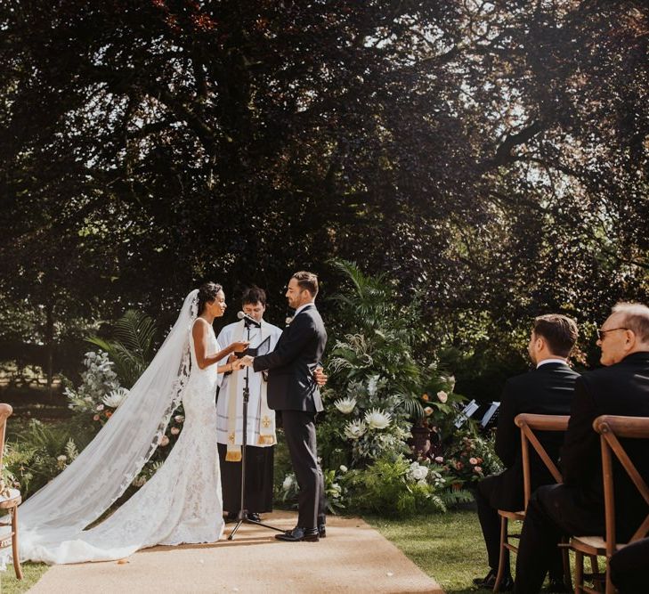 Bride and groom exchanging vows at outdoor wedding ceremony