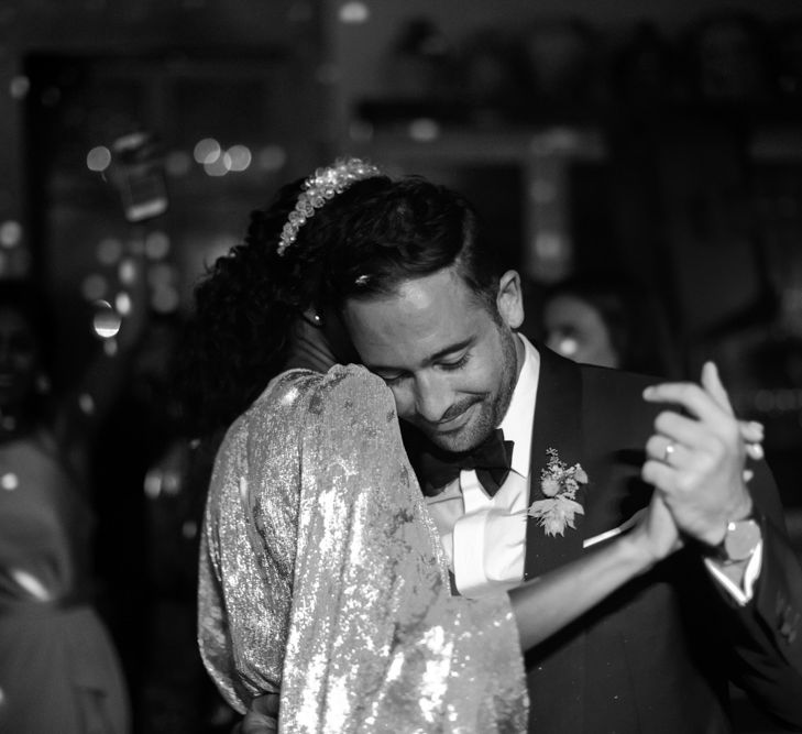 Bride and groom embracing on the dance floor at evening reception