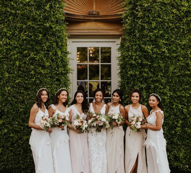 Bridal party portrait with bridesmaids in white dresses and bride in lace dress