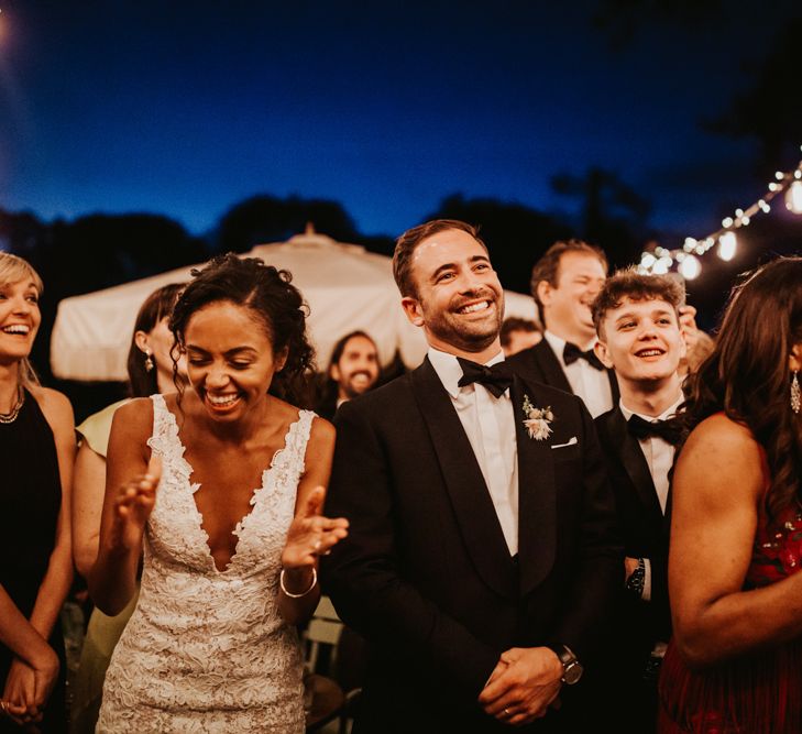 Bride and groom laughing during outdoor wedding speeches