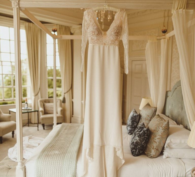 Anna Georgina wedding dress hanging up on four poster bed