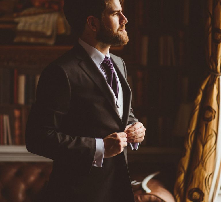 Groom in grey lounge suit with purple tie