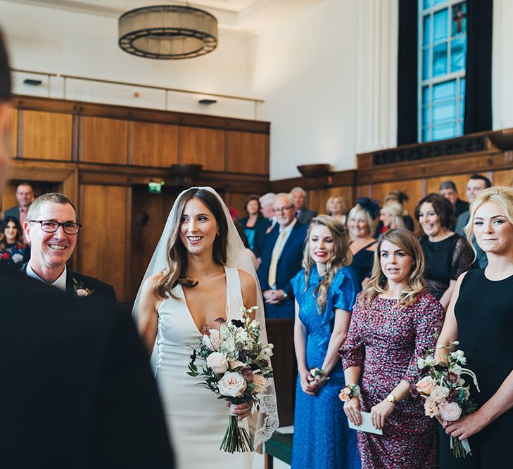 Bride walking to the Groom and bridesmaids in elegant black bridesmaid dresses