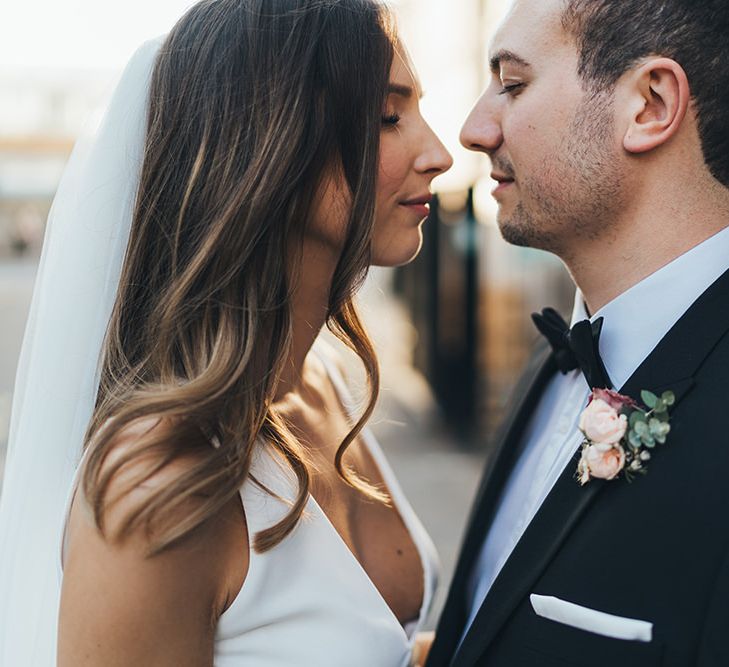 Bride and Groom embrace at city autumn wedding