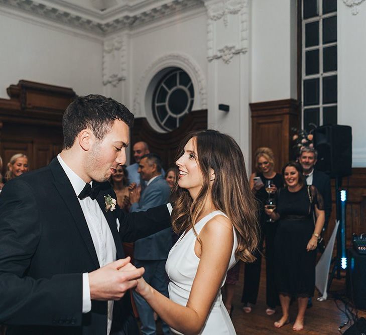 Bride and Grooms first dance at city wedding reception with black tie fashion and black bridesmaid dresses