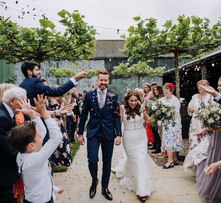 Confetti Moment with Bride in Lace Roland Joyce Bridal Wedding Dress and Groom in Navy Suit