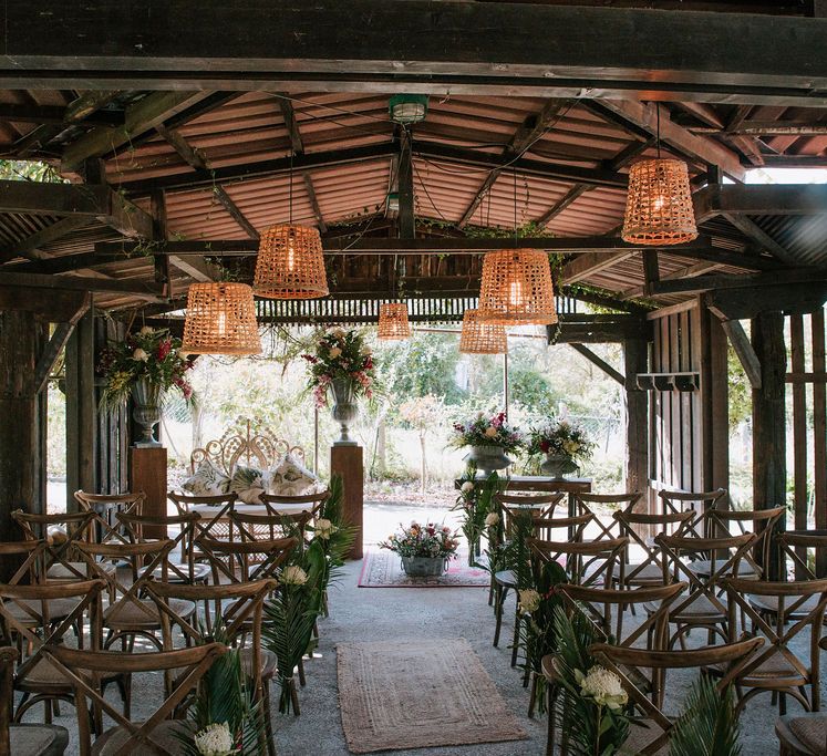 wooden ‘pagoda’ wedding ceremony with wicker lamps and botanical plant decor