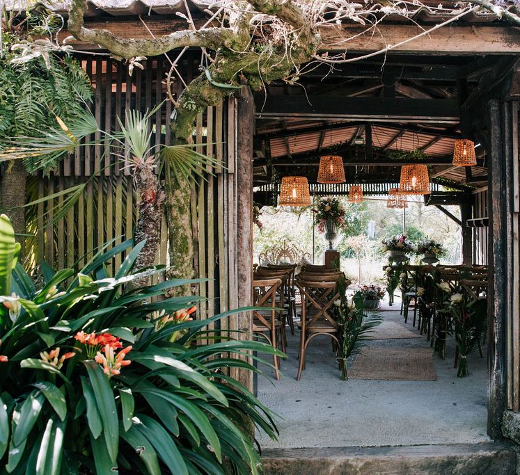 wooden ‘pagoda’ wedding ceremony with wicker lamps, botanical plant decor and Moroccan rugs decor