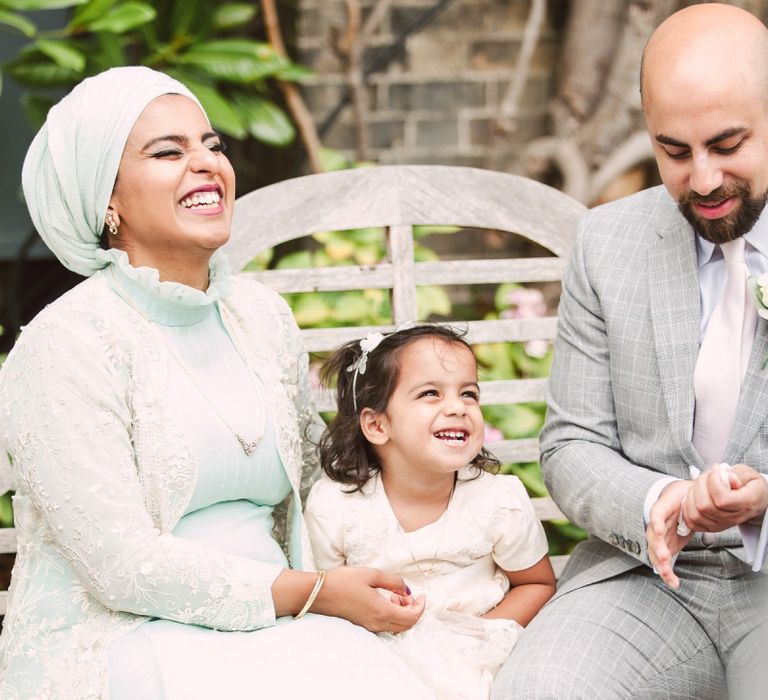 Flower Girl and Her Parents Laughing on a Bench