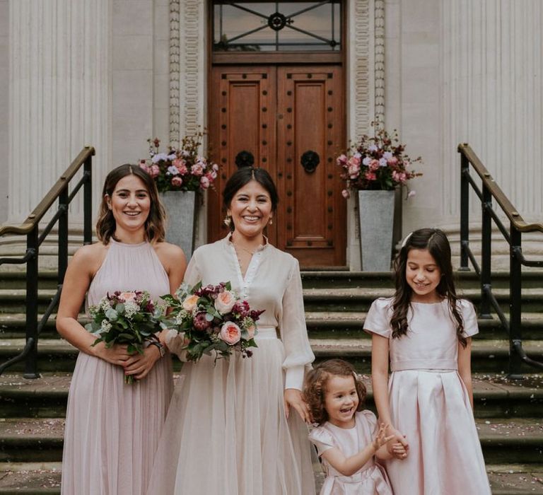 Bride and bridesmaid standing on the steps at Old Marylebone Town Hall