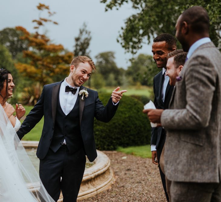 Bride and groom being congratulated by friends and family