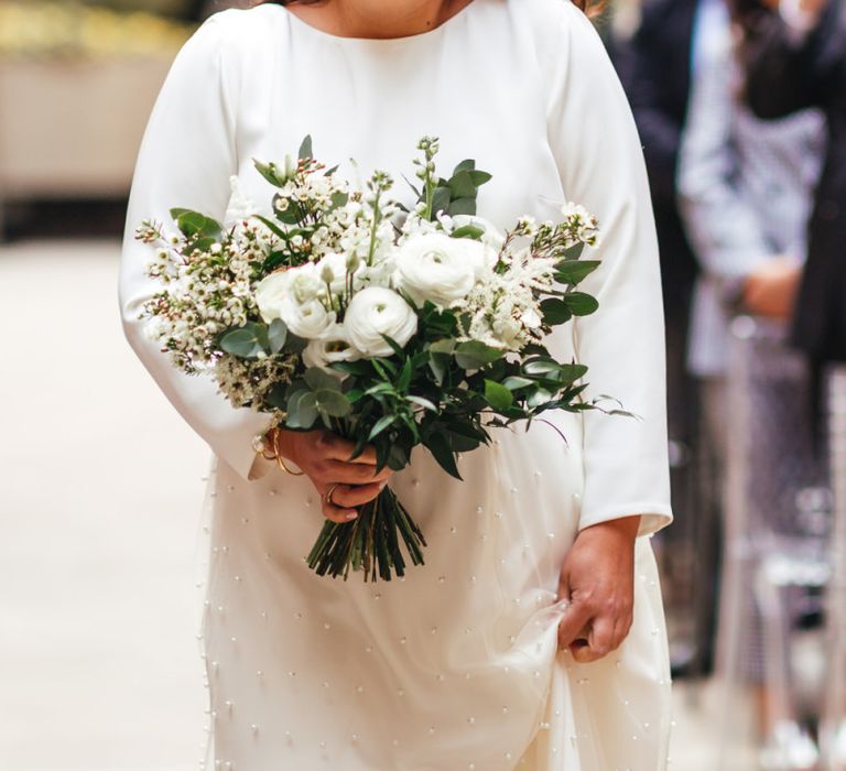 Bride wearing two piece dress and white floral bouquet