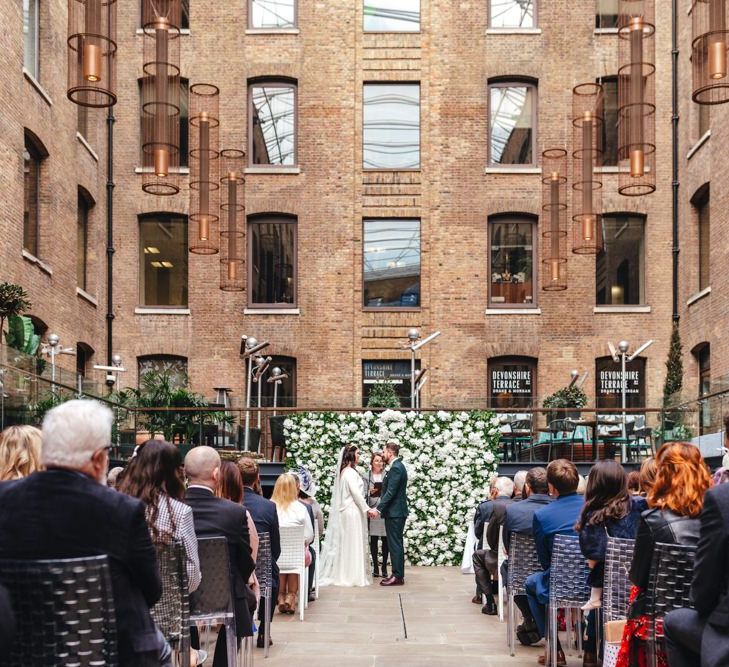 Spring courtyard wedding at Devonshire Terrace with white floral decor