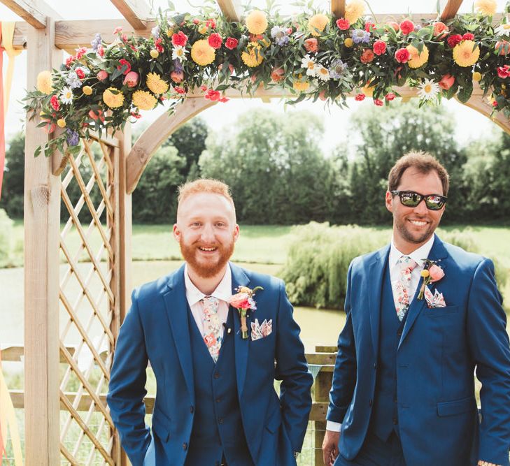 Groom at the Flower Covered Altar in Navy Suit | Bright Festival Themed Outdoor Ceremony &amp; Tipi Weeding |  Maryanne Weddings | Framed Beauty Film