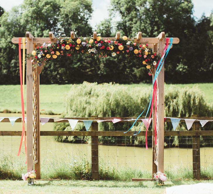 Flower Covered Arbour | Bright Festival Themed Outdoor Ceremony &amp; Tipi Weeding |  Maryanne Weddings | Framed Beauty Film