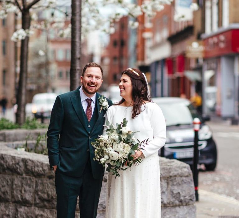 Bride wearing two piece dress with beautiful white floral bouquet