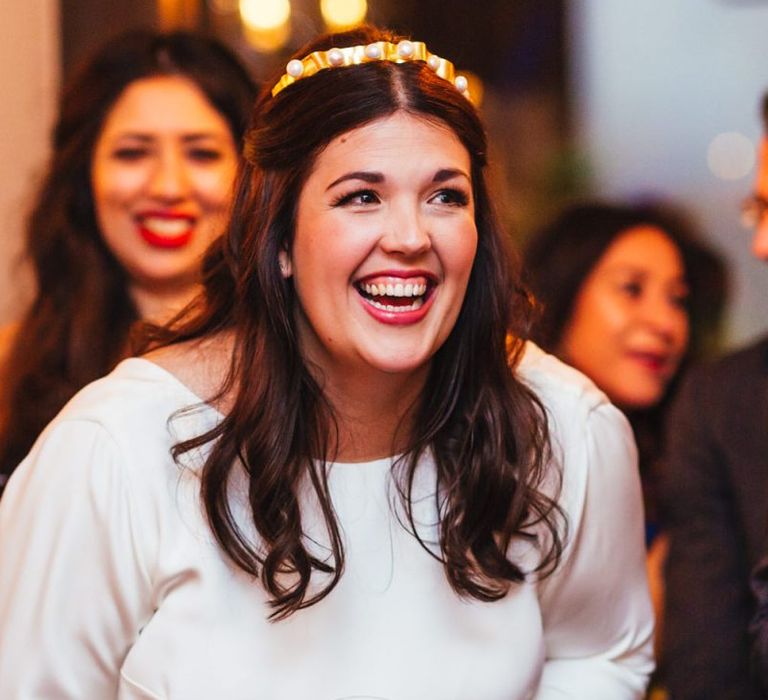 Bride looks beautiful with soft waved hair and embellished accessory