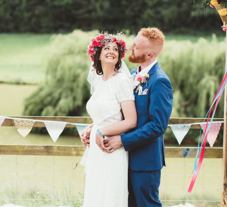 Bride in Lace Watters Gown &amp; Colourful Flower Crown | Groom in Navy Suit | Bright Festival Themed Outdoor Ceremony &amp; Tipi Weeding |  Maryanne Weddings | Framed Beauty Film