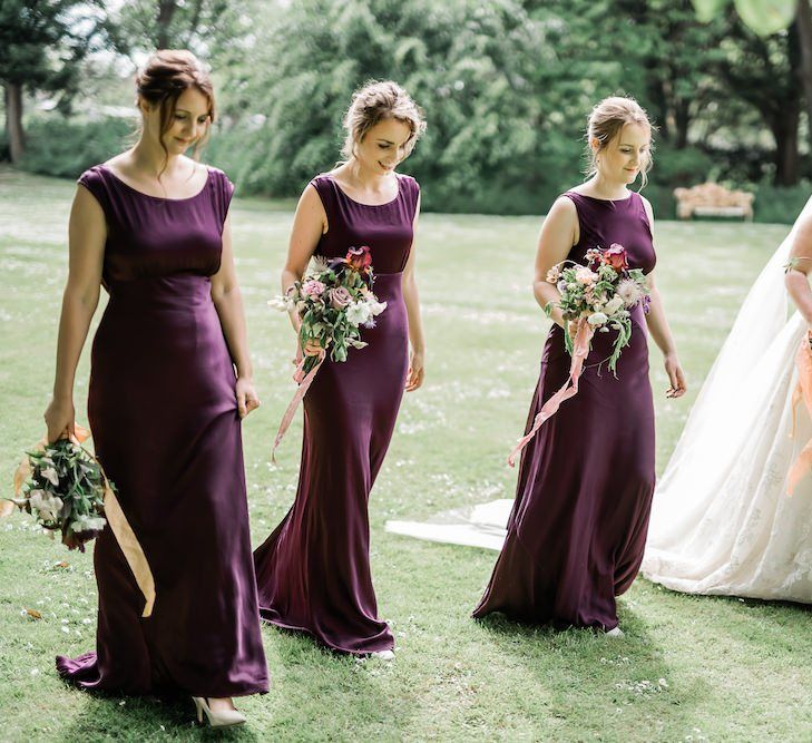 Bridal Party Portrait with Bride in Lace Sophia Tolli Wedding Dress and Bridesmaids in Deep Purple Satin Dresses