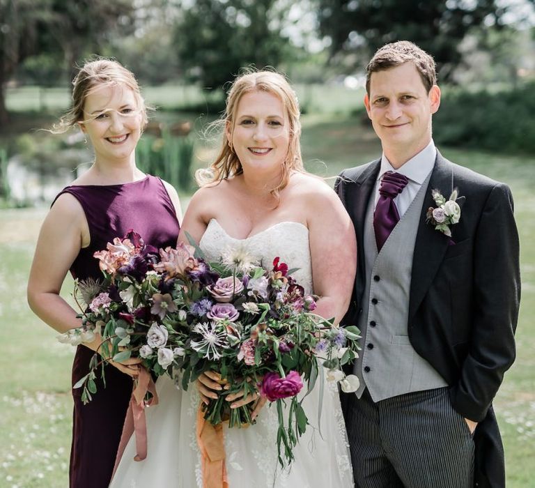 Bride in Lace Sophia Tolli Wedding Dress with Bridesmaids in a Purple Dress and Groomsman a Traditional Wedding Suit