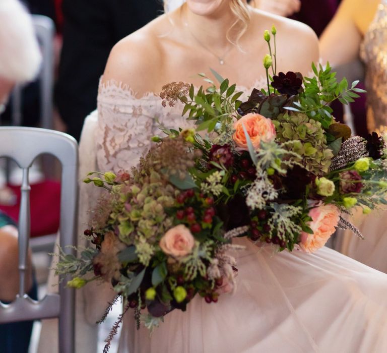 Laughing Bridesmaids in Pink Bardot Monsoon Wedding Dress Holding Deep Red and Green Winter Bouquet