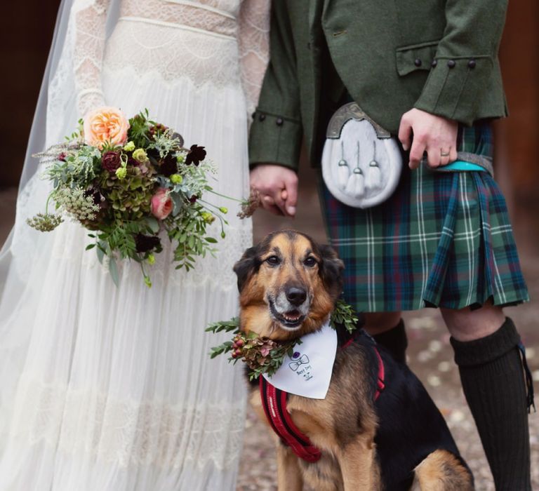 Bride in Delicate Lace Lihi Hod Sophia Wedding Dress with Long Sleeves and Groom in Traditional Tartan Kilt Posing with Pet Dog