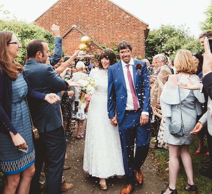 Confetti Moment with Bride in Lace Wedding Dress from Hope &amp; Harlequin and Groom in Navy Hugo Boss Suit