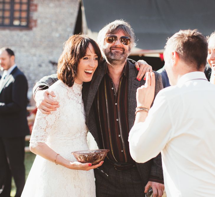 Bride in Lace Wedding Dress from Hope &amp; Harlequin Talking to Wedding Guests