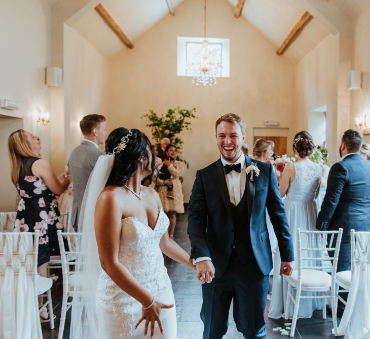 Bride and groom walking up the aisle as husband and wife