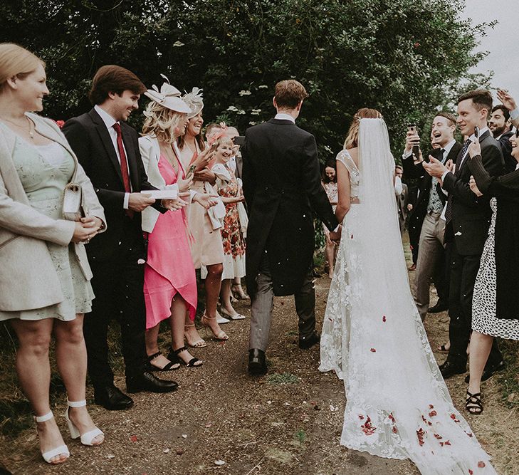 Confetti Exit | Bride in Lace Rime Arodaky Wedding Dress | Groom in Henry Herbert Tailors Suit | English Country Garden Marquee Wedding at the Family Home on the Isle of Wight | Jason Mark Harris Photography