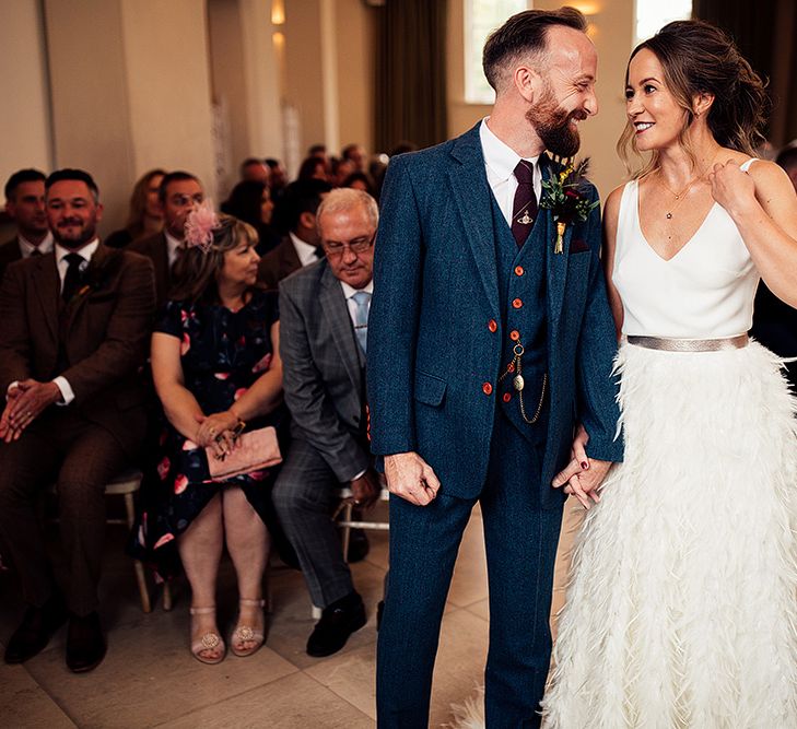 Bride in Charlie Brear Payton Bridal Gown &amp; Piora Feather Skirt at The Altar with Her Groom