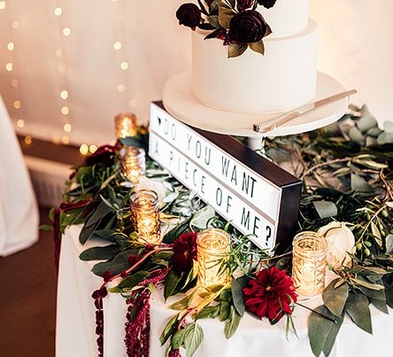 Elegant Wedding Cake with Floral Skirt and 'Do You Want a Piece of Me' Light Box Sign