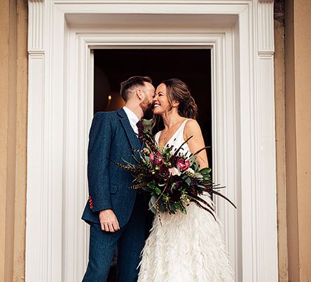 Bride in a Charlie Brear Payton Bridal Gown &amp; Piora Feather Skirt and Groom in a Navy Suit