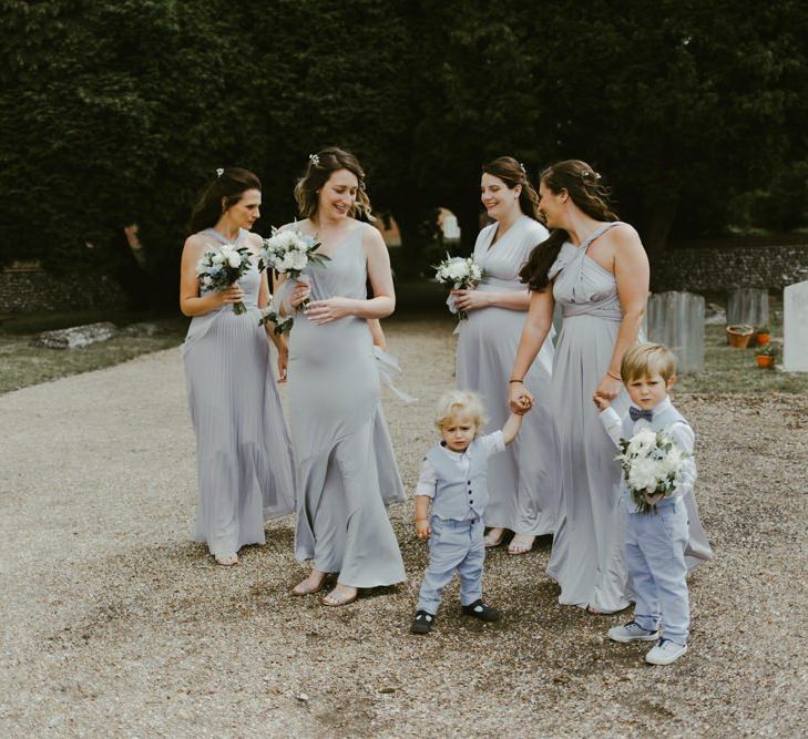 Bridesmaids in blue dresses arrive at church ceremony