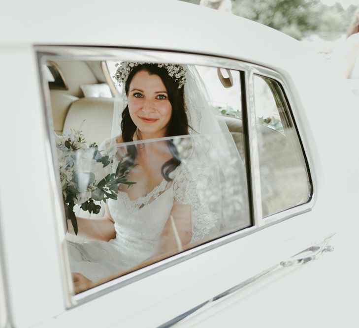 Bride arrives in classic white wedding car