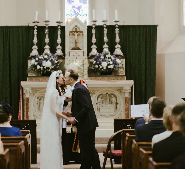 Bride and groom kiss at Church wedding ceremony