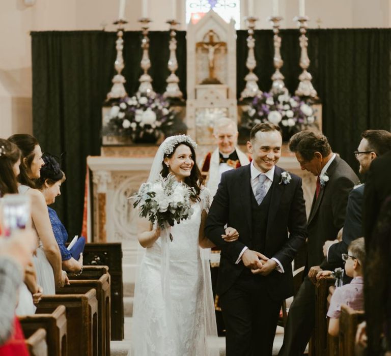 Newlywed couple walk back up the aisle