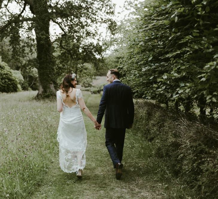 Bride and groom walk through the grounds of Ramster Hall