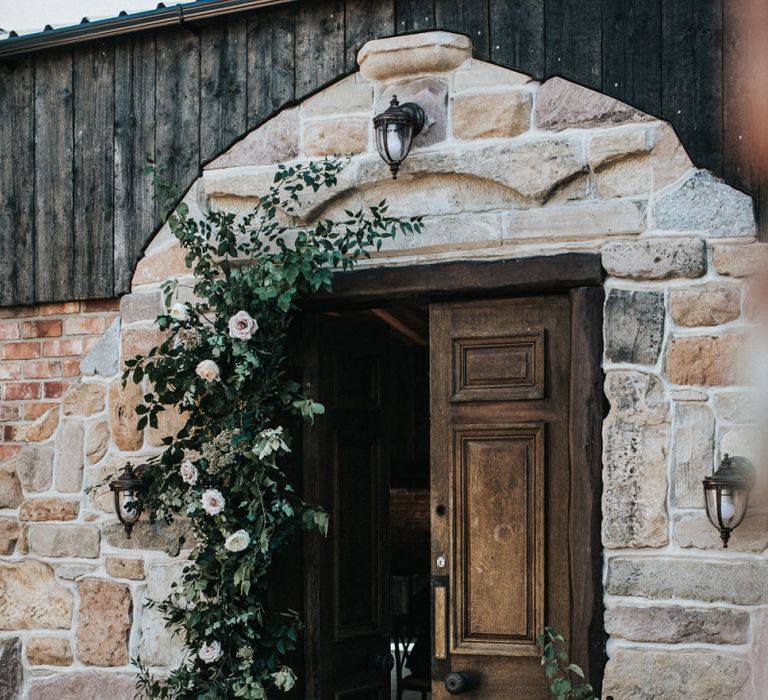 Wedding Floral Arrangement Lining the Doorway to the Wedding Venue